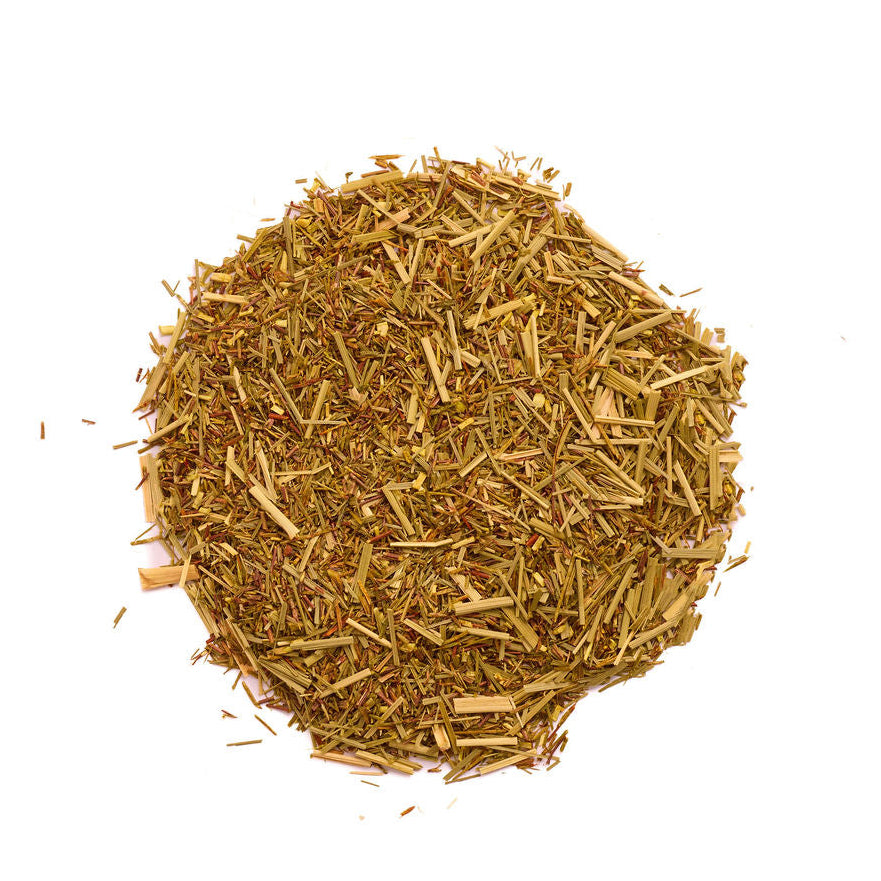 A small mound of loose-leaf herbal tea or spice blend in golden-brown and tan tones, photographed from above on a plain white background.