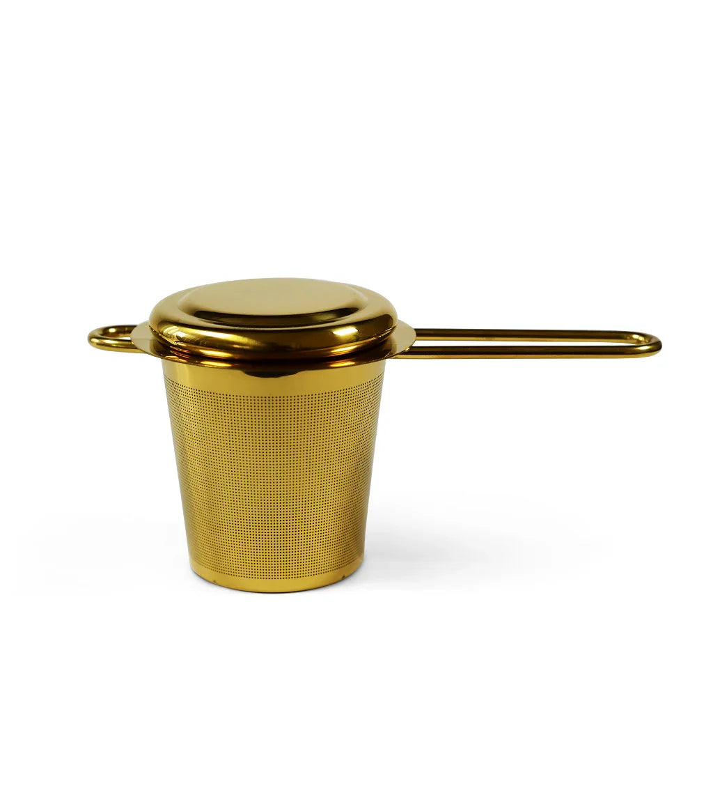 Gold stainless steel tea infuser strainer with lid and long handle on white background
