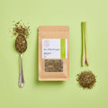A stand-up kraft paper pouch of Green Rooibos & Lemongrass caffeine-free tea, featuring a white and green label with a clear window showing the loose tea inside, set against a plain white background.