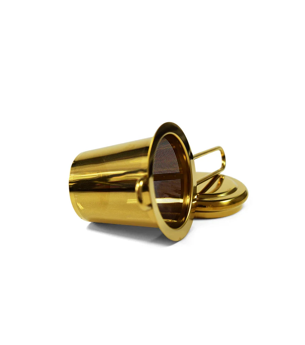 Gold metal tea strainer with fine mesh and handle, resting on matching lid against white background