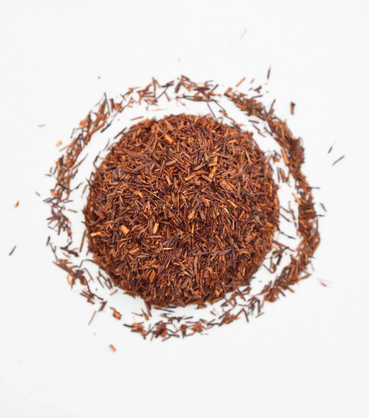 Close-up of loose-leaf organic Rooibos Bourbon Vanilla tea on white background
