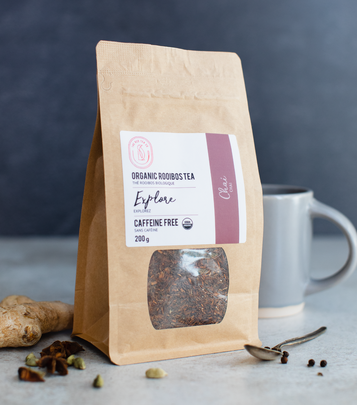 Red Tea Co Rooibos Chai Packaging with grey mug and fresh spices
